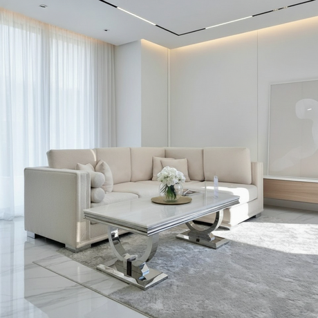 Modern living room with a beige sectional sofa and glass coffee table.