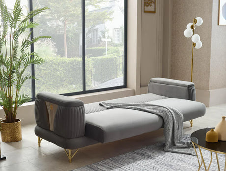 Modern living room with a gray sofa, plant, and decorative items.