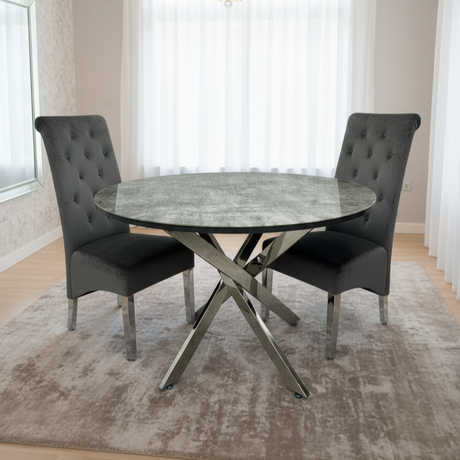 Round dining table with marble-like surface and two gray chairs in a well-lit room.