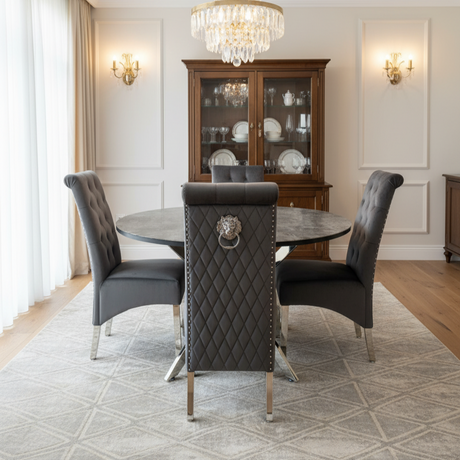 Dining room with round table and gray chairs, featuring a chandelier and wooden cabinet.
